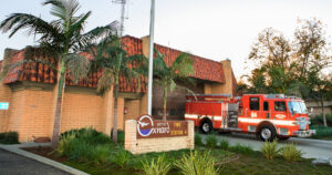 Fire station 4 with palm trees in the front, engine 64 parked in the driveway and the City of Oxnard sign located on the lawn.