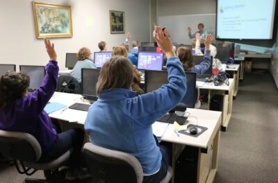 People sitting at desks in a training session.