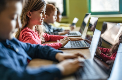 Children doing library research on their laptops.