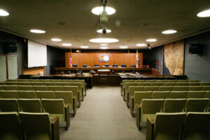 Interior of the Oxnard City Council Chambers with rows of chairs facing the Council Members' seats.